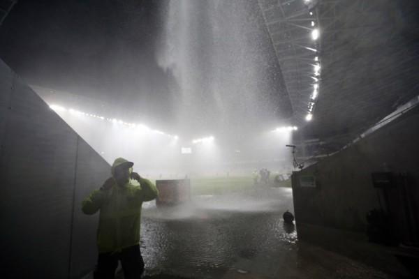 People protect themselves from a heavy shower as the French L1 football match Nice (OGC Nice) vs Nantes (FCN) is interrupted, on October 03, 2015 at the "Allianz Riviera" stadium in Nice, southeastern France.  AFP PHOTO / VALERY HACHE